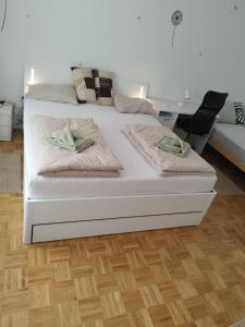 un letto bianco con due cuscini sopra di Apartma MB center a Maribor