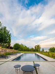 una piscina con sillas y mesas en un patio en Hotel Pepe Vieira Relais & Châteaux en Raxo