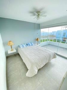 um quarto com uma cama grande e uma parede de vidro em PARADISUS PARACAS Gran Casa de Playa con Jacuzzi! em Paracas