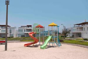 - une aire de jeux avec des toboggans dans un parc avec des bâtiments dans l'établissement PARADISUS PARACAS Gran Casa de Playa con Jacuzzi!, à Paracas