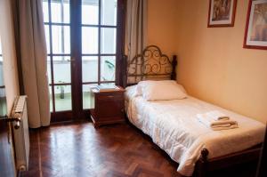 1 dormitorio con 1 cama, mesita de noche y ventana en Aires de Salta II 3 pisos por escalera en Salta