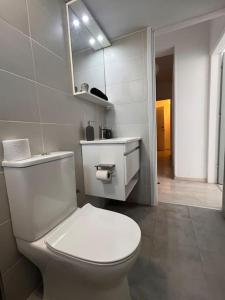 a bathroom with a white toilet and a sink at Top floor Flat in Nicosia 2 in Nicosia