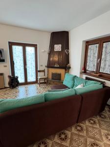 a living room with a couch and a fireplace at Casa del Sole in Castione della Presolana