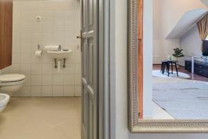 uma casa de banho com um WC, um lavatório e um espelho. em Appartamento Quattroporte em Budapeste