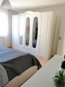 um quarto com uma cama e um grande armário branco em Geräumige schöne Ferienwohnung em Weingarten
