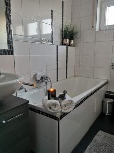 uma casa de banho com uma banheira com uma vela e toalhas em Geräumige schöne Ferienwohnung em Weingarten