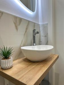 ein Badezimmer mit einem weißen Waschbecken auf einer Holztheke in der Unterkunft Camera Brera Difronte San Siro in Mailand