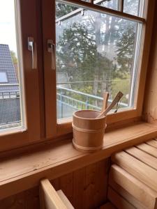un rebord de fenêtre avec un seau et deux ustensiles dans l'établissement Familienzeit, moderne Ferienwohnung mit Sauna in Timmendorfer Strand, à Timmendorfer Strand