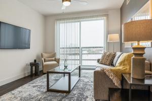 a living room with a couch and a tv at Landing at City North - 2 Bedrooms in Valley Ranch in Irving