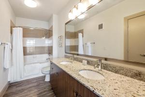 a bathroom with two sinks and a toilet and a mirror at Landing at City North - 2 Bedrooms in Valley Ranch in Irving
