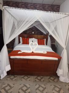 um quarto com uma cama com dois cisnes em Queen's Way Resort em Kisumu