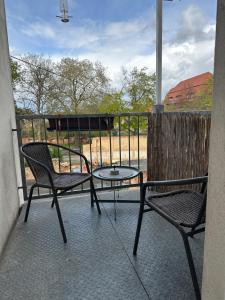 d'une terrasse avec 2 chaises et une table sur un balcon. dans l'établissement Ferienwohnung Zeitz Appartment Moritzburg, à Zeitz