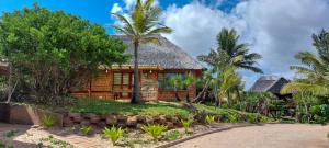 una casa con techo de paja y palmeras en Bay View Lodge, en Miramar