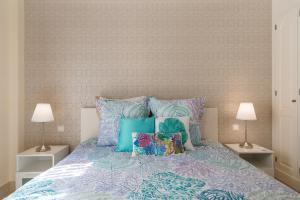 Schlafzimmer mit einem Bett mit blauen und violetten Kissen in der Unterkunft Beautiful Flat with heated pool near the beach in Arguineguín + 9 Fotos