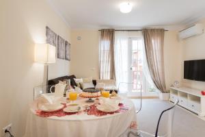 ein Wohnzimmer mit einem Tisch mit Speisen und Getränken darauf in der Unterkunft Beautiful Flat with heated pool near the beach in Arguineguín