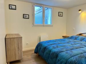 ein Schlafzimmer mit einem blauen Bett und einem Fenster in der Unterkunft 357 - Appartement T3 à 100m de l'Anse du Croc. in Frehel