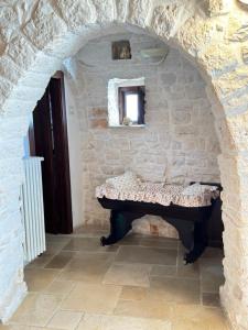 Habitación con una mesa en una pared de piedra. en Trulli Aia Piccola, en Alberobello
