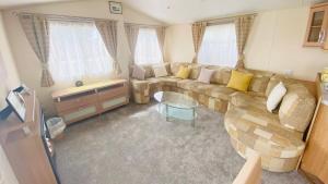 a living room with a couch and a table at Pen y Maes Caravan in Criccieth