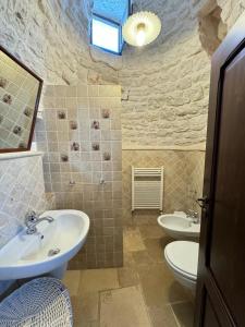 アルベロベッロにあるTrulli Aia Piccolaのバスルーム(洗面台2つ、トイレ2つ付)