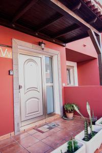 Villa Florymar في إيخينيو: باب منزل به نباتات الفخار