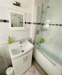 ein Badezimmer mit einem Waschbecken, einer Badewanne und einer Dusche in der Unterkunft Mount Pleasant Retreat in Troed-y-rhiw