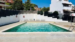 una piscina de agua azul frente a un edificio en Mediterranean house, pool, beach and charm garden, en Arenys de Mar