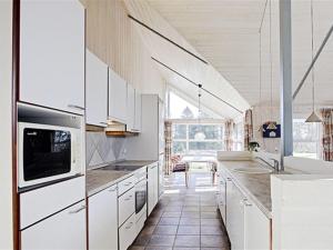 een keuken met witte kasten en een groot raam bij Holiday Home Carit - all inclusive - 80m from the sea by Interhome in Odder