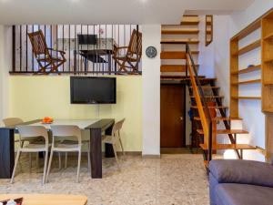 - un salon avec une table, des chaises et une télévision dans l'établissement Apartment Giulia by Interhome, à Luino