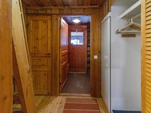a hallway of a cabin with a door and a refrigerator at Holiday Home Keidaskero b 9 by Interhome in Pyhätunturi