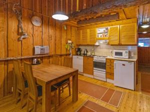 a kitchen with wooden walls and a wooden table at Holiday Home Keidaskero b 9 by Interhome in Pyhätunturi +8 photos