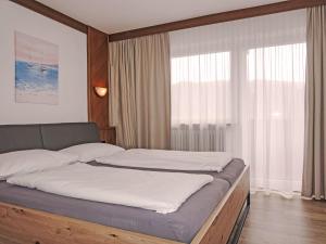 a bed in a room with a large window at Apartment Ferienhaus Friedl-2 by Interhome in Imst