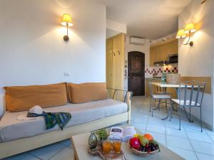 - un salon avec un canapé et une table avec des fruits dans l'établissement Apartment Cala Rossa 1505 by Interhome, à Trinità d'Agultu e Vignola