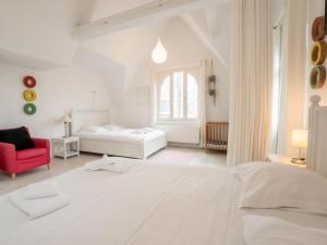 - une chambre blanche avec un lit et une chaise rouge dans l'établissement Villa Villa Charlemagne by Interhome, à Blankenberge