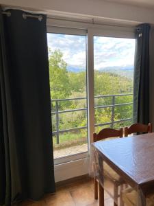 a room with a window with a table and a view at La casa degli Ulivi in Camporosso
