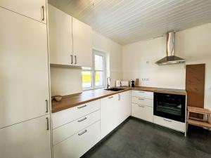 eine Küche mit weißen Schränken und einem Fenster in der Unterkunft Apartment Rachel by Interhome in Velden am Wörthersee