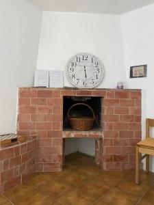a clock sitting on top of a brick fireplace at La casa degli Ulivi in Camporosso