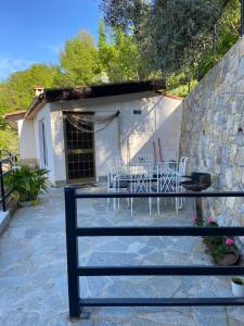 eine Terrasse mit Stühlen und einem Tisch vor einem Gebäude in der Unterkunft La casa degli Ulivi in Camporosso