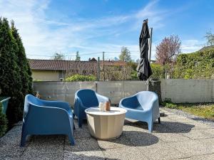 eine Gruppe Stühle und ein Sonnenschirm auf einer Terrasse in der Unterkunft Apartment Rachel by Interhome in Velden am Wörthersee