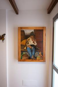 een schilderij van een jongen zittend op een bank met een vlinder bij Villa Florymar in Ingenio
