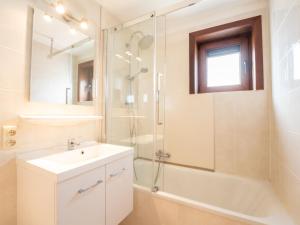 een witte badkamer met een wastafel en een douche bij Holiday Home Casa by Interhome in De Haan
