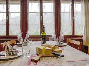 a table with a bottle of wine and cheese on it at Apartment Reinisch by Interhome in Frutigen