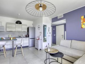 ein Wohnzimmer und eine Küche mit einem Sofa und einem Tisch in der Unterkunft Apartment Les Terrasses d'Azur-2 by Interhome in Sanary-sur-Mer