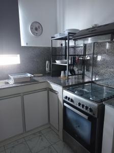 Il comprend une cuisine équipée d'un four et de plaques de cuisson. dans l'établissement Appartement Cosy, à Beau Bassin-Rose Hill