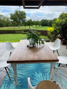a wooden table and chairs on a patio at Lovely Family Home / Pecanwood Golf Estate in Hartbeespoort