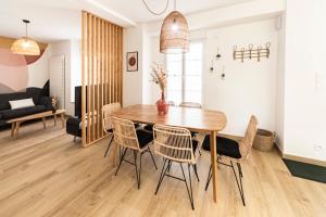 comedor y sala de estar con mesa de madera y sillas en Le Clos de la Jouvence - Gite 4* à 15 minutes du Puy du Fou, 6 personnes en Saint-Laurent-sur-Sèvre