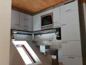 uma cozinha com armários brancos e um micro-ondas em Apartment Frankenau-38 by Interhome em Frankenau