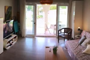 Una sala de estar con un sofá y un televisor. en Alojamientos Nerja Costa, en Nerja