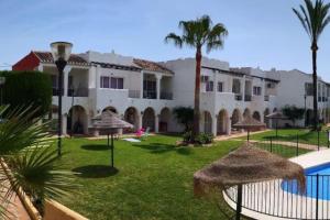 Un complejo con un patio con sombrillas y una piscina. en Alojamientos Nerja Costa, en Nerja