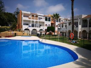 Una gran piscina azul frente a un edificio en Alojamientos Nerja Costa, en Nerja