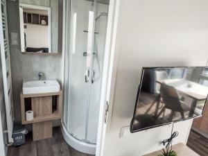 y baño con ducha, lavabo y espejo. en Holiday Home Tiny Haus Altmühlblick by Interhome en Beilngries